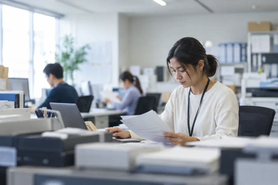 オフィスで書類を確認する担当者（イメージ）